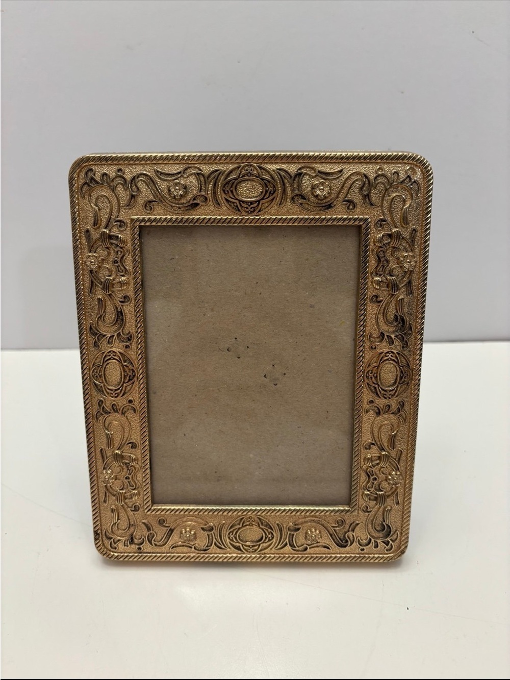 ornate, vintage-style tabletop picture frame with an antique gold-toned finish